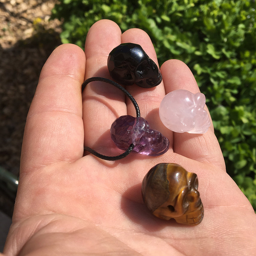 Pendentif en forme de crâne, symbole de la connaissance ! De 18 millimètres de hauteur x 16 mm de largeur. Pierre au choix : Améthyste, Obsidienne, Quartz rose, Oeil de tigre. Vendu avec cordon noir réglable offert, parfait !