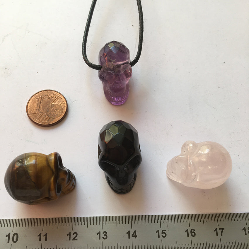 Pendentif en forme de crâne, symbole de la connaissance ! De 18 millimètres de hauteur x 16 mm de largeur. Pierre au choix : Améthyste, Obsidienne, Quartz rose, Oeil de tigre. Vendu avec cordon noir réglable offert, parfait !