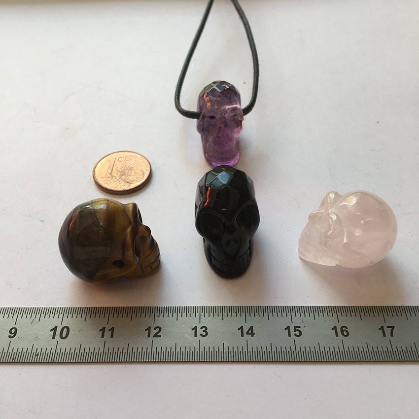 Pendentif en forme de crâne, symbole de la connaissance ! De 18 millimètres de hauteur x 16 mm de largeur. Pierre au choix : Améthyste, Obsidienne, Quartz rose, Oeil de tigre. Vendu avec cordon noir réglable offert, parfait !