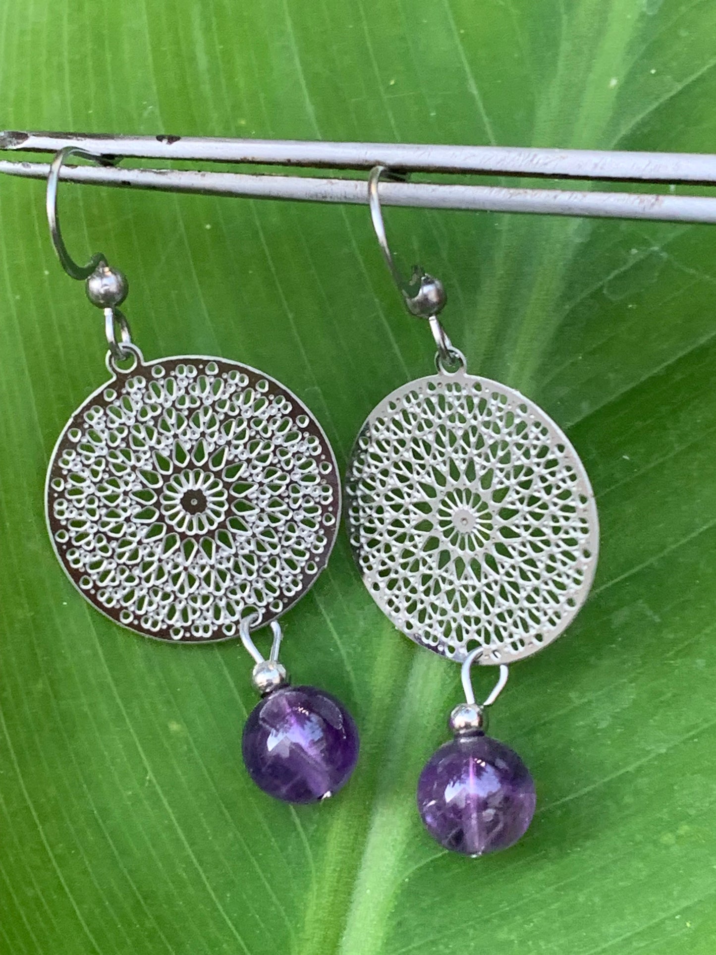 Boucles d'oreilles en Améthyste avec un superbe Mandala en Argent où est suspendue une perle ronde, qualité AA à AAA. Vendu en finition Argent 0.925, parfait !