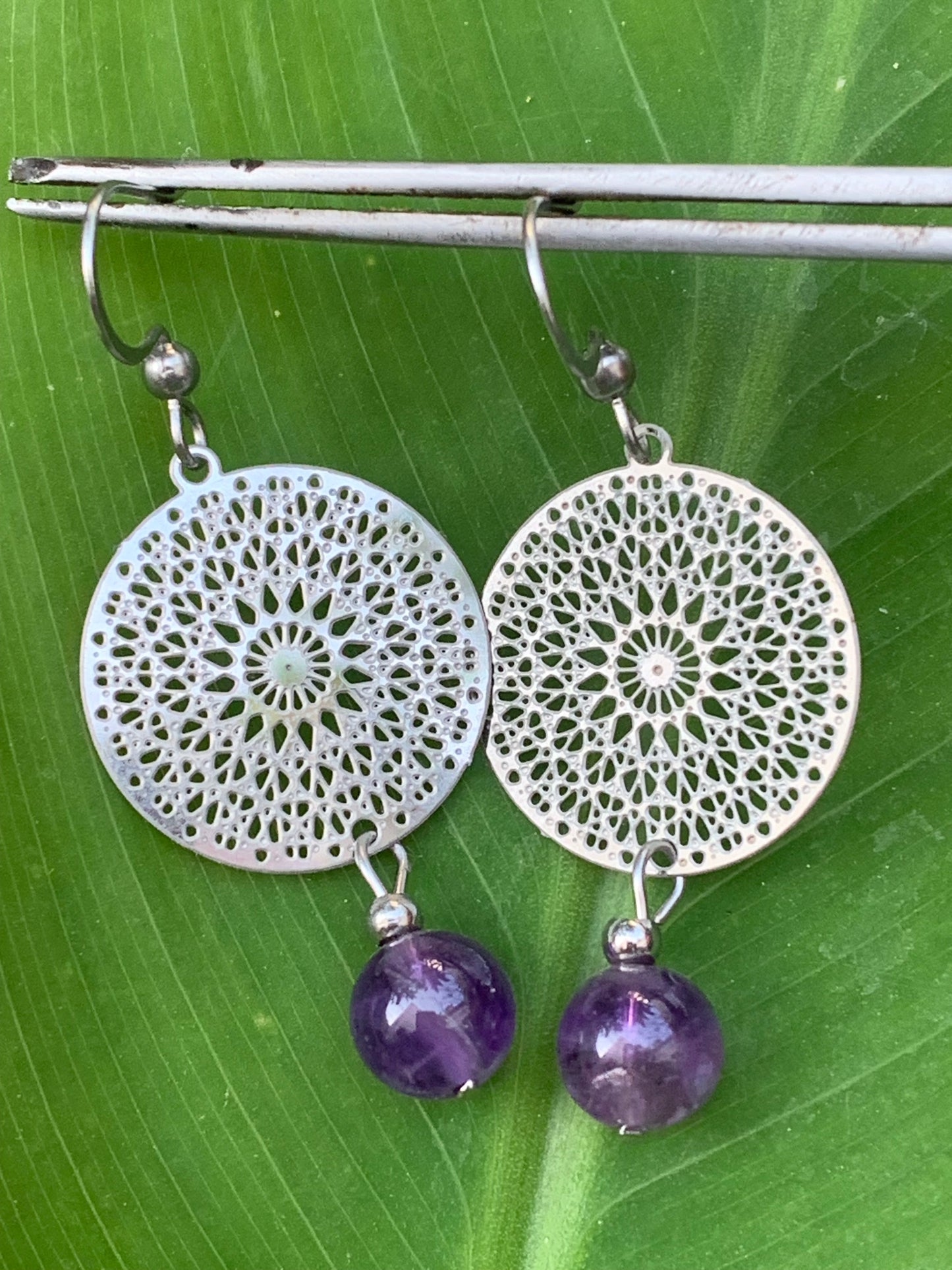 Boucles d'oreilles en Améthyste avec un superbe Mandala en Argent où est suspendue une perle ronde, qualité AA à AAA. Vendu en finition Argent 0.925, parfait !
