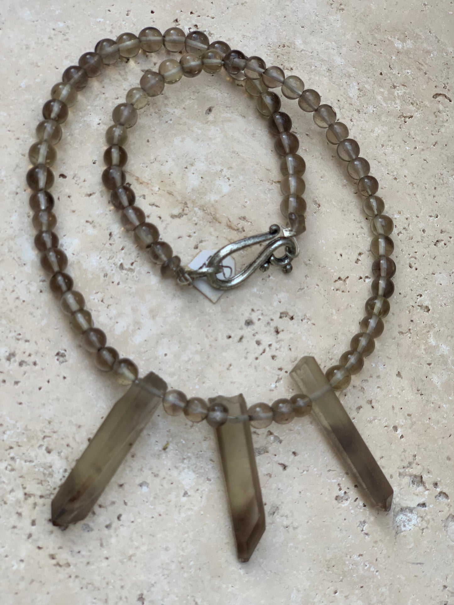 Cristal de roche/ Quartz fumé, en collier de 42 centimètres. Perle rondes de 4 à 7 millimètres avec 3 cristaux naturels en panoramique, fermoir de type 'crochet' !