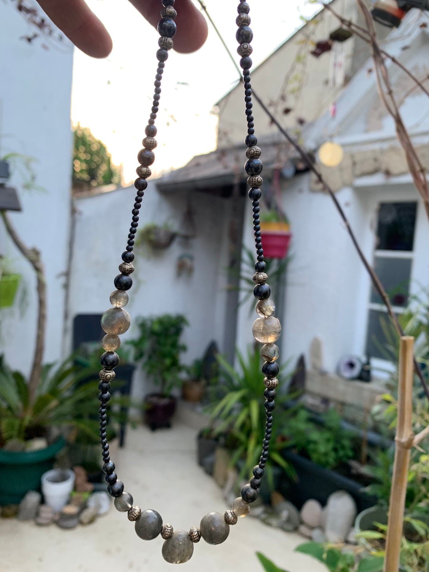 Labradorite avec hématite, 'collier/ chute de perle', de forme ronde de 2 à 10 millimètres de diamètre. 45 centimètres de longueur, fermoir à vis. Très belle pièce montée par Gem & Zen !