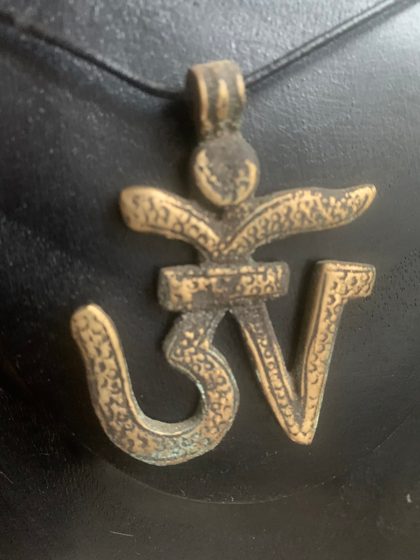 Om, symbole sacré en métal (laiton), taille de 60x50x10 millimètres. Pièce authentique et unique faîte au Népal. Livré avec cordon coulissant, prêt à porté ou à offrir !