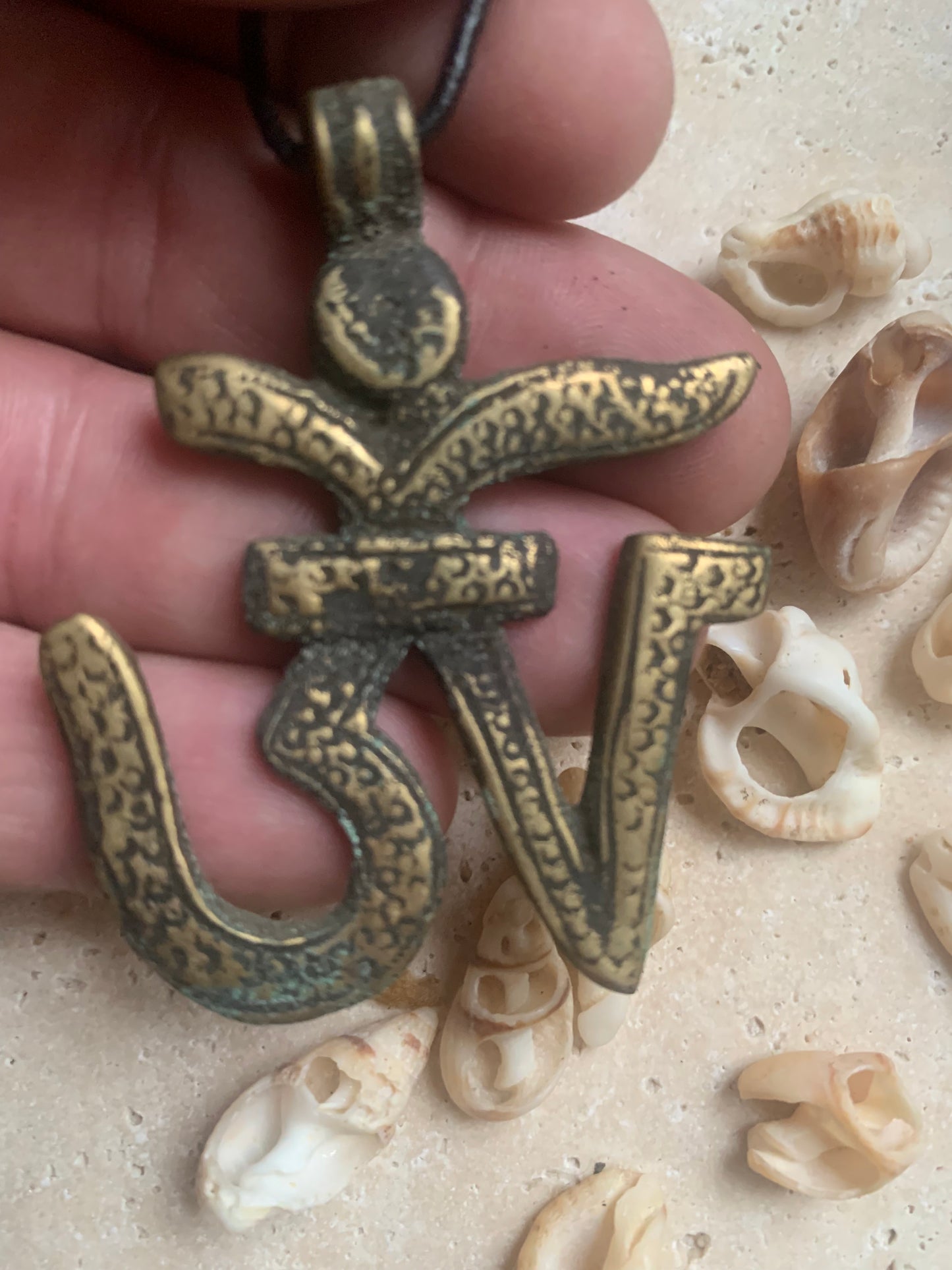 Om, symbole sacré en métal (laiton), taille de 60x50x10 millimètres. Pièce authentique et unique faîte au Népal. Livré avec cordon coulissant, prêt à porté ou à offrir !