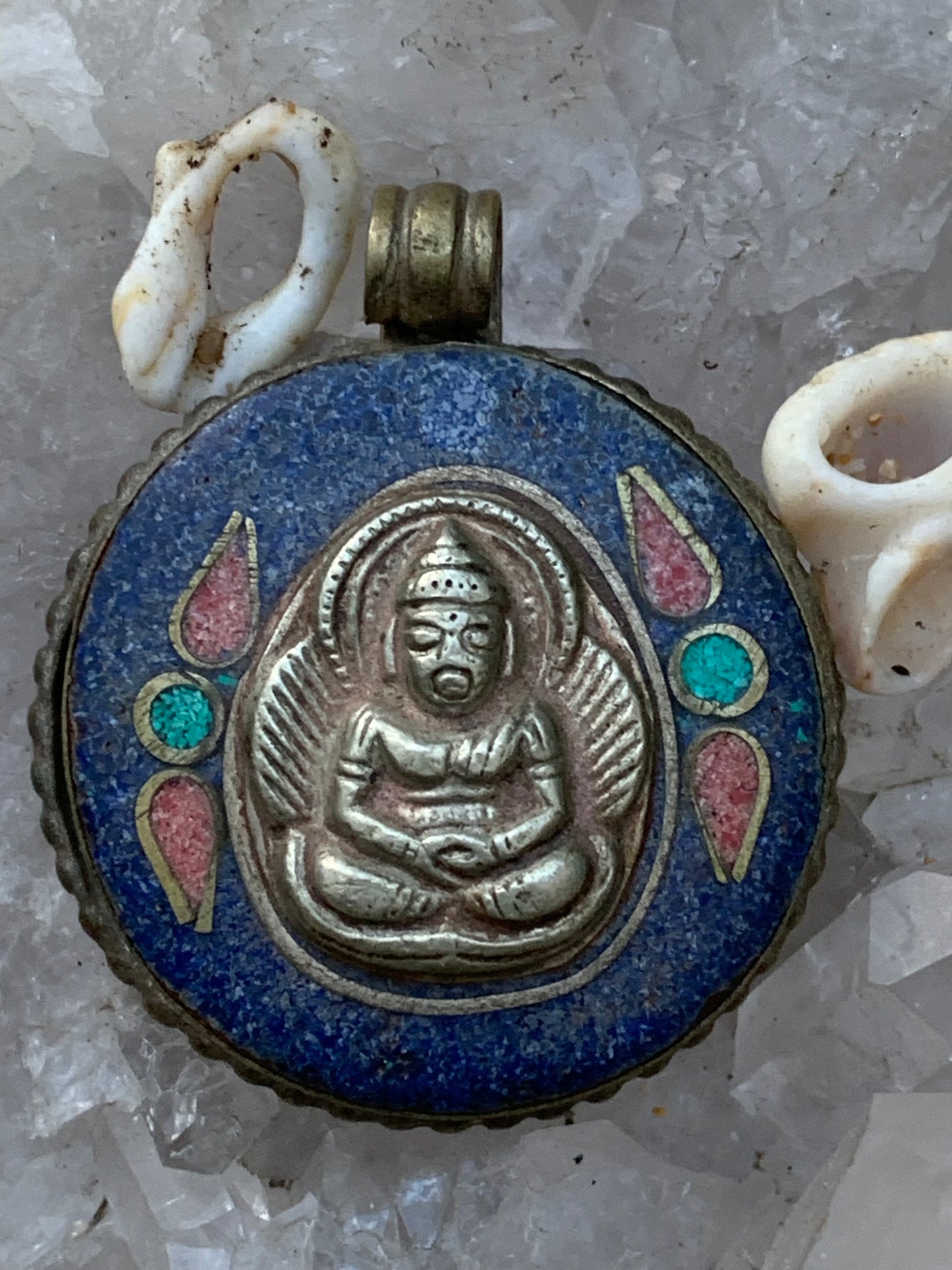 Bouddha, pendentif en lapis lazuli, corail et turquoise sur métal ton argent de 35 millimètres de diamètre. Avec de magnifiques gravures sur la face arrière. Livré avec cordon coulissant (offert), prêt à porté ou à offrir, parfait !
