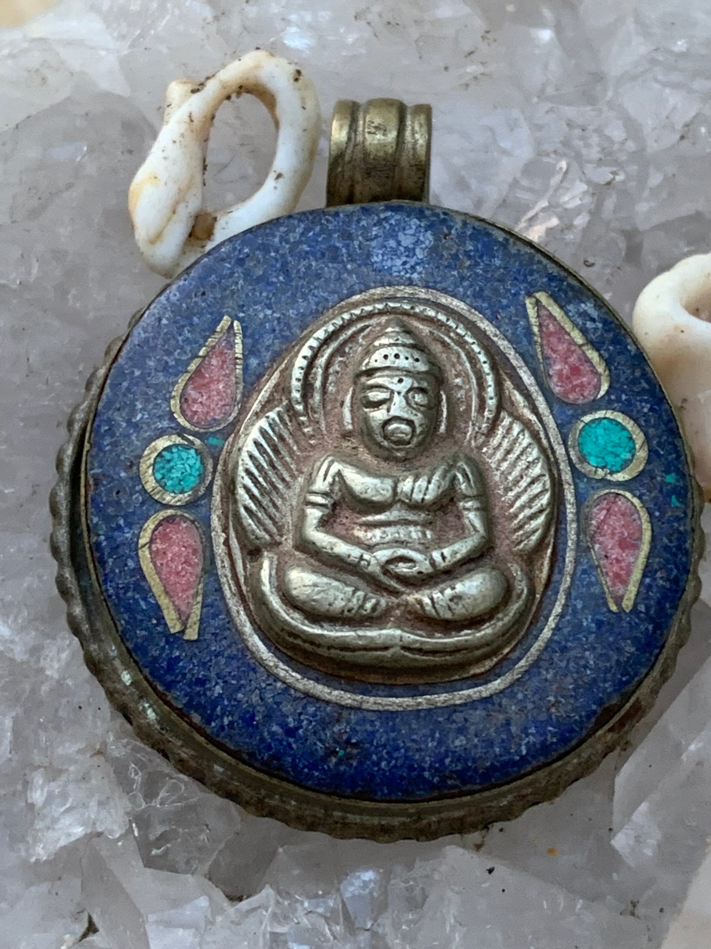 Bouddha, pendentif en lapis lazuli, corail et turquoise sur métal ton argent de 35 millimètres de diamètre. Avec de magnifiques gravures sur la face arrière. Livré avec cordon coulissant (offert), prêt à porté ou à offrir, parfait !