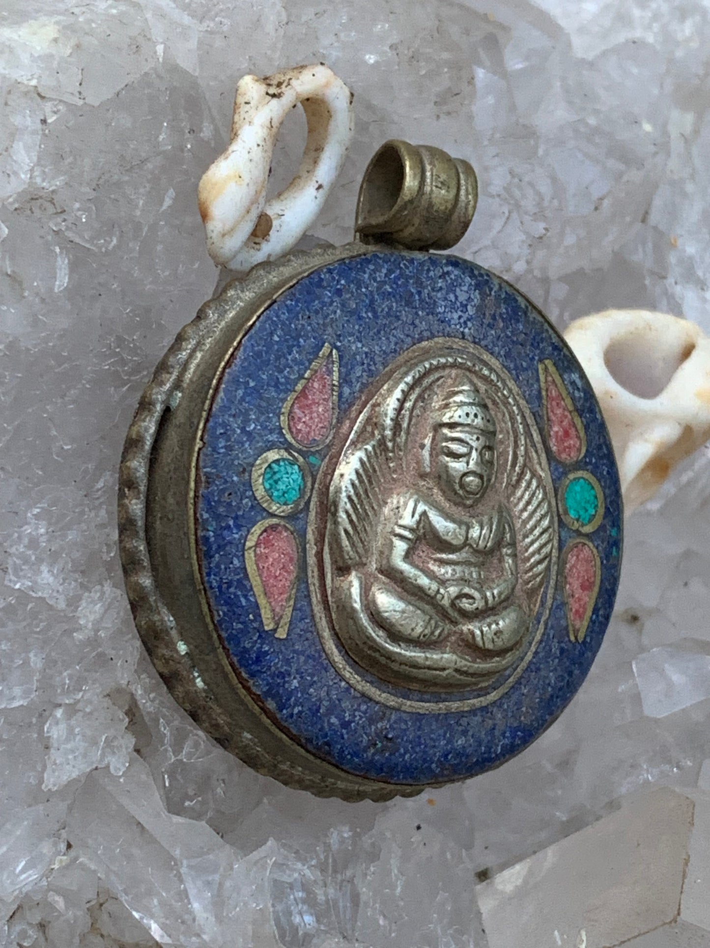 Bouddha, pendentif en lapis lazuli, corail et turquoise sur métal ton argent de 35 millimètres de diamètre. Avec de magnifiques gravures sur la face arrière. Livré avec cordon coulissant (offert), prêt à porté ou à offrir, parfait !