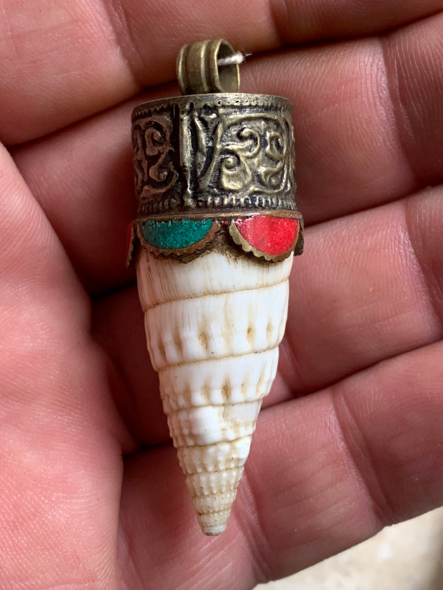 Pendentif artisanal du Népal en coquillage sertis en métal avec de jolies gravures et de la turquoise avec du corail ! De 53 millimètres de hauteur x 18 mm de diamètre. Vendu avec cordon noir réglable offert, parfait !