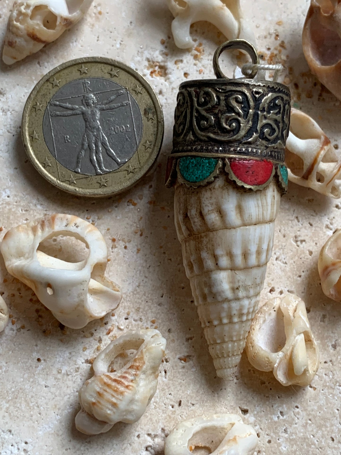 Pendentif artisanal du Népal en coquillage sertis en métal avec de jolies gravures et de la turquoise avec du corail ! De 53 millimètres de hauteur x 18 mm de diamètre. Vendu avec cordon noir réglable offert, parfait !