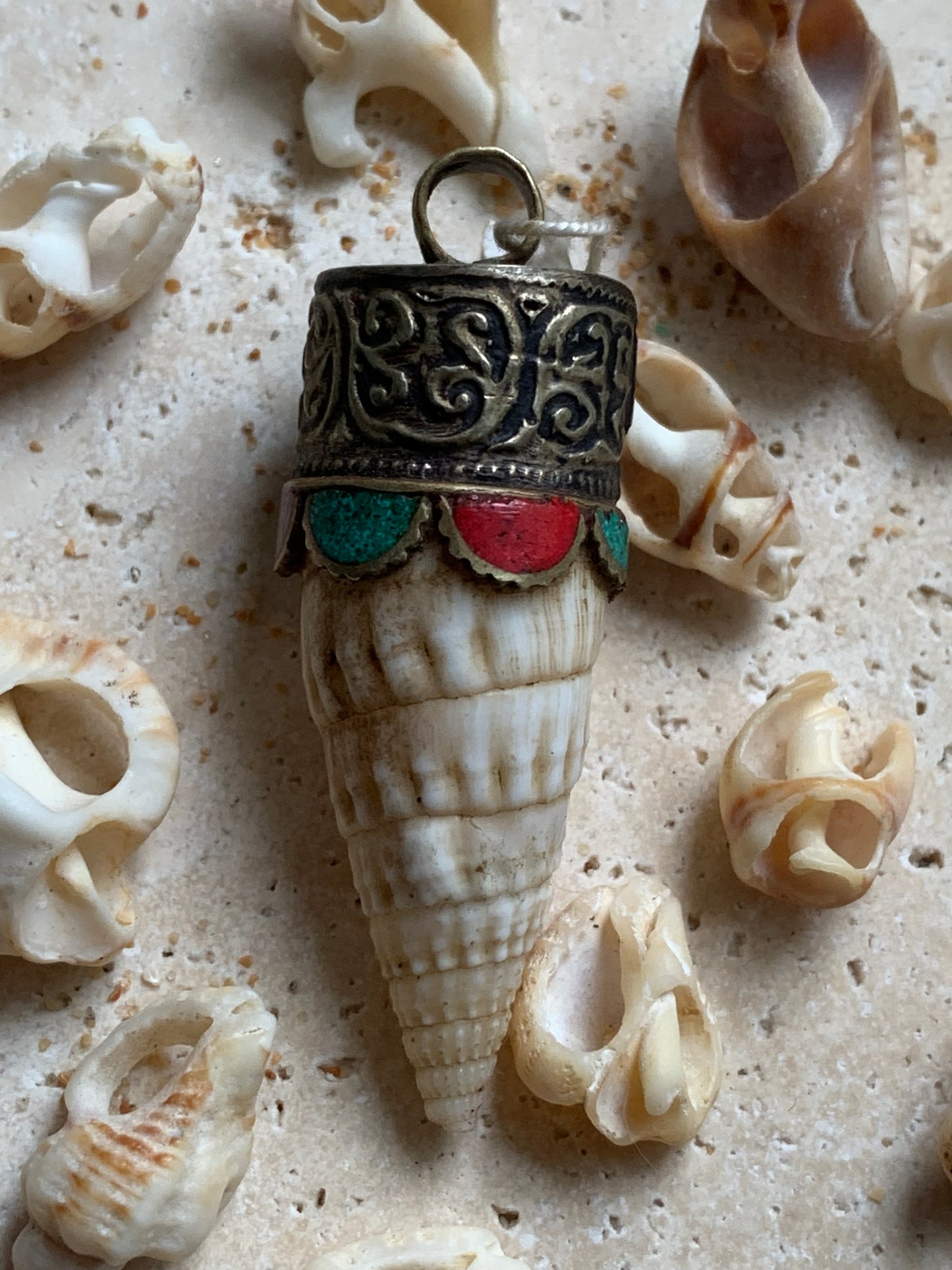 Pendentif artisanal du Népal en coquillage sertis en métal avec de jolies gravures et de la turquoise avec du corail ! De 53 millimètres de hauteur x 18 mm de diamètre. Vendu avec cordon noir réglable offert, parfait !