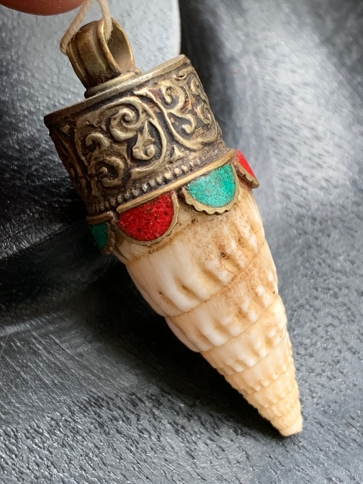 Pendentif artisanal du Népal en coquillage sertis en métal avec de jolies gravures et de la turquoise avec du corail ! De 53 millimètres de hauteur x 18 mm de diamètre. Vendu avec cordon noir réglable offert, parfait !