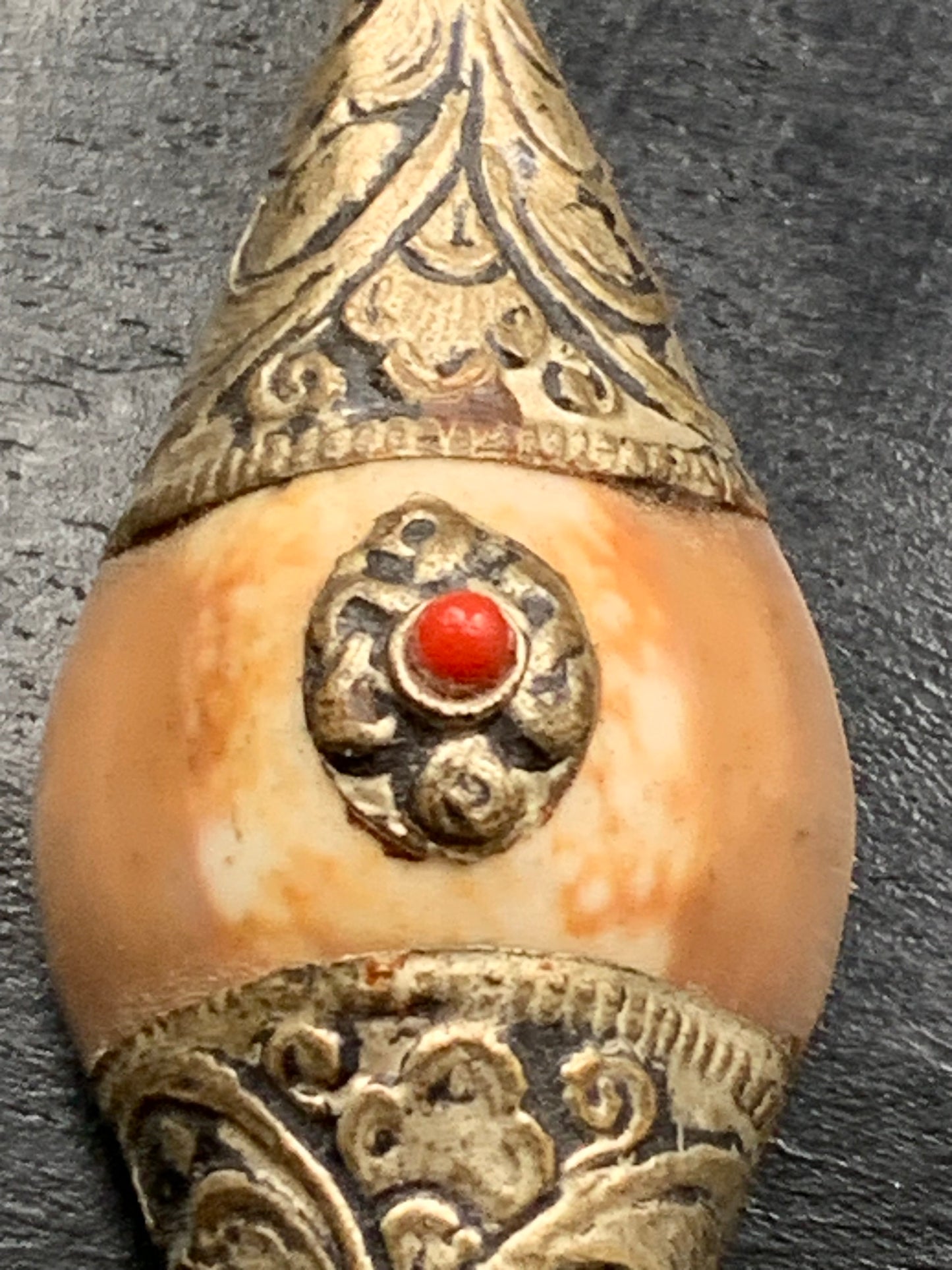 Pendentif artisanal du Népal en coquillage sertis en métal avec de jolies gravures et une perle de corail ! De 60 millimètres de hauteur x 23 mm de largeur x 16 d'épaisseur. Vendu avec cordon noir réglable offert, parfait !