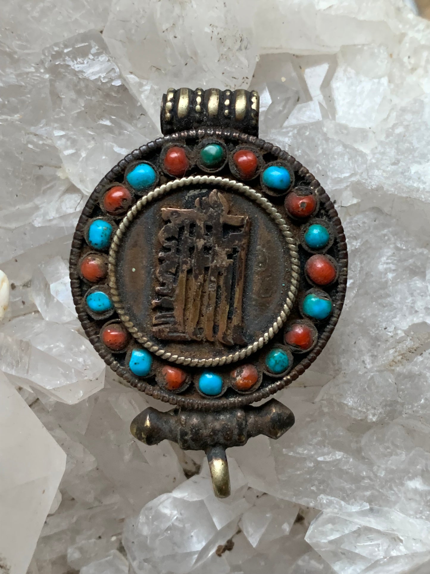 Handcrafted pendant/reliquary from Nepal with turquoise and coral stones set on metal with a beautiful Om engraving! 52 millimeters high x 35 mm wide x 11 mm thick. Sold with a free adjustable black cord, perfect!