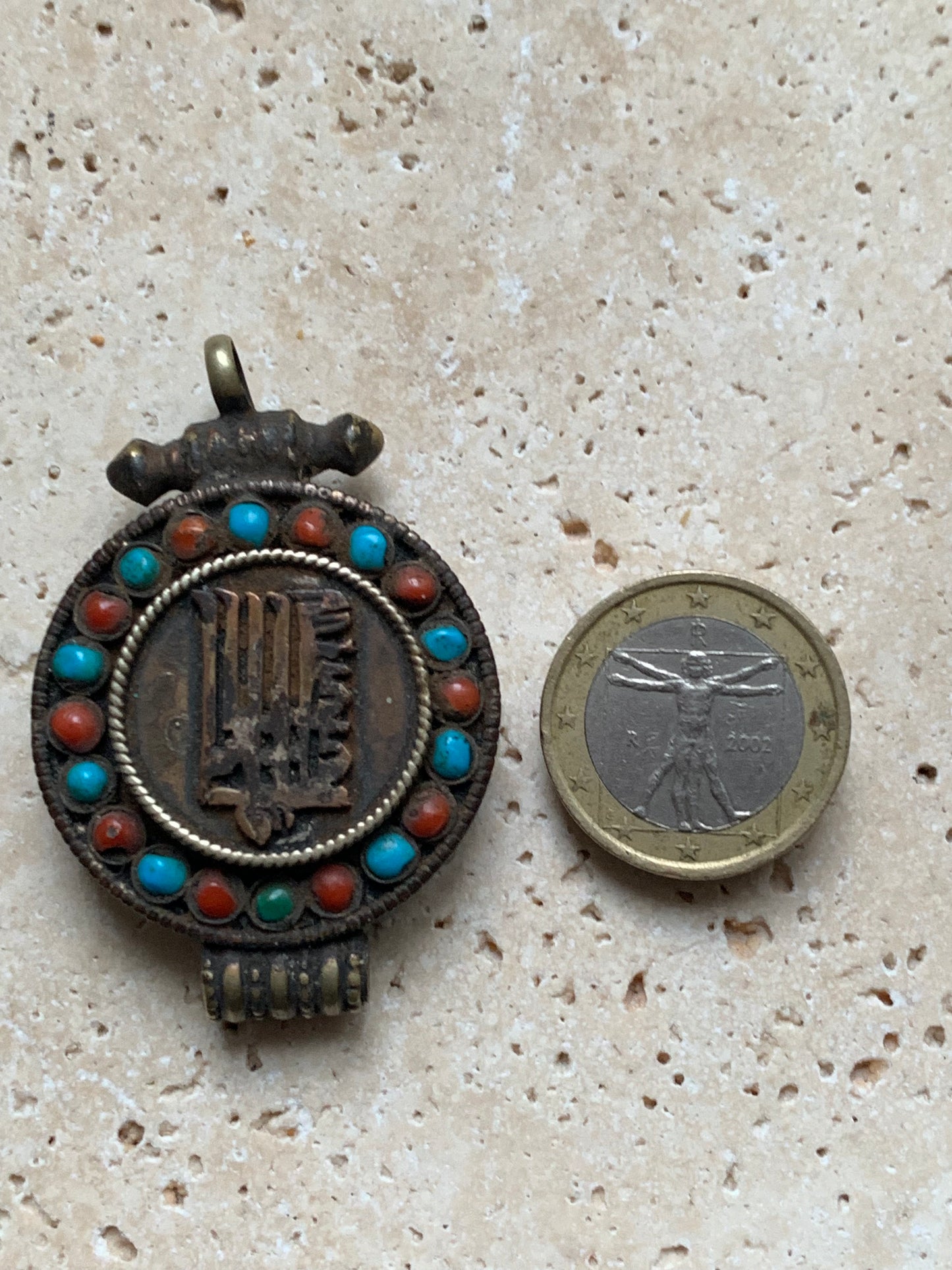 Handcrafted pendant/reliquary from Nepal with turquoise and coral stones set on metal with a beautiful Om engraving! 52 millimeters high x 35 mm wide x 11 mm thick. Sold with a free adjustable black cord, perfect!