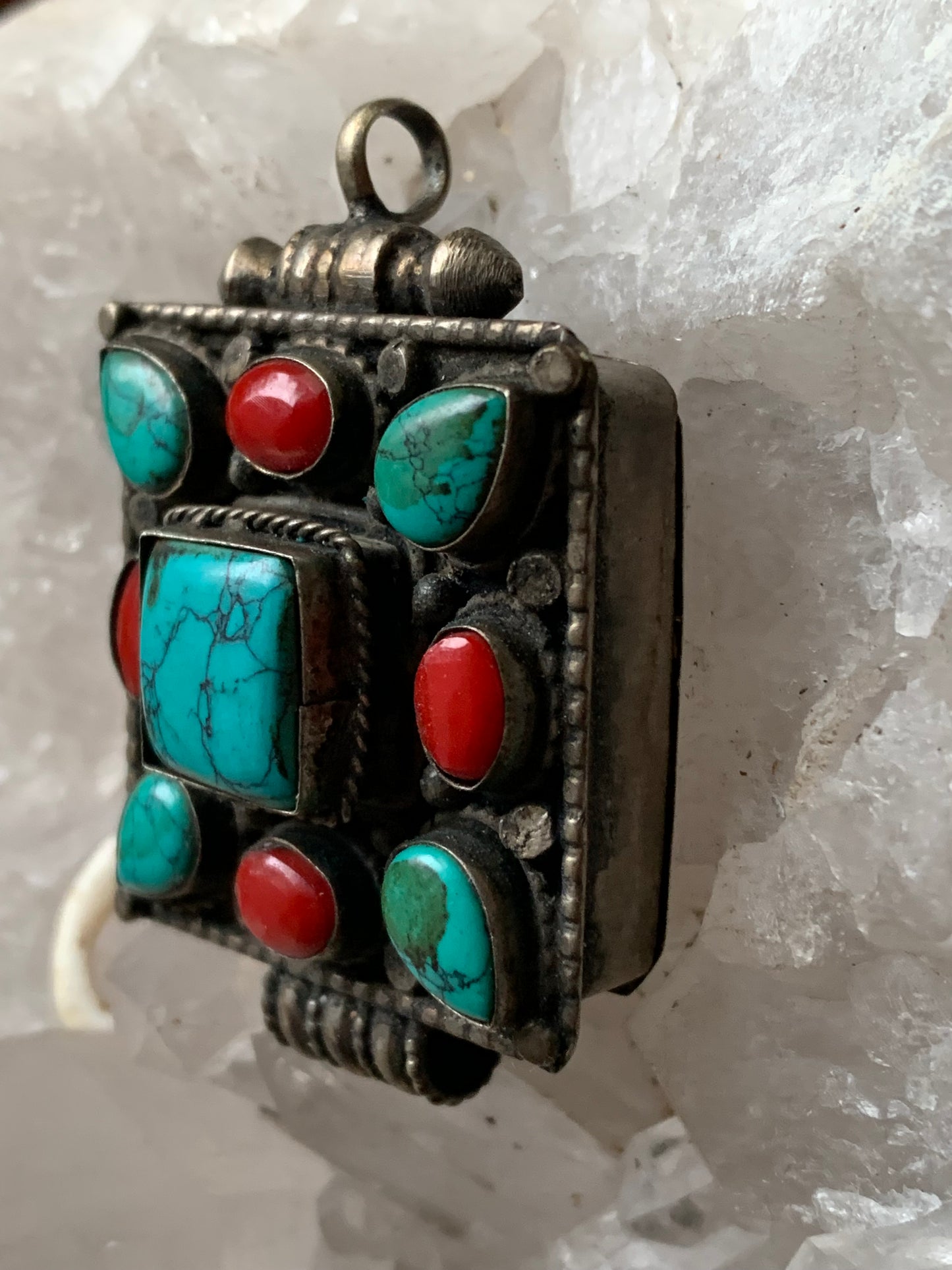 Pendentif/ Reliquaire artisanal du Népal avec pierres de turquoise et de corail sertis sur méta ! De 50 millimètres de hauteur x 35 mm de largeur x 17 d'épaisseur. Vendu avec cordon noir réglable offert, parfait !