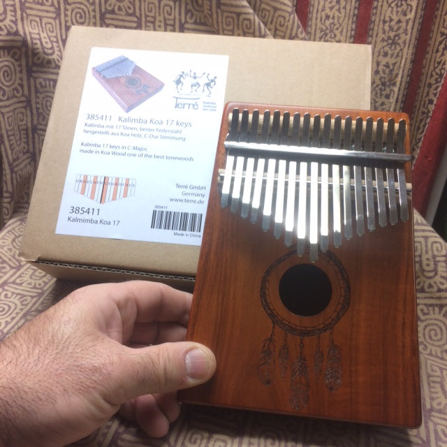 The kalimba or finger piano! 17 notes, made of koa wood (tropical resonance wood) in the key of C major. Decorated with a carved Indian motif and comes with a cloth bag and a tuning hammer! 23x19x7.5 cm!