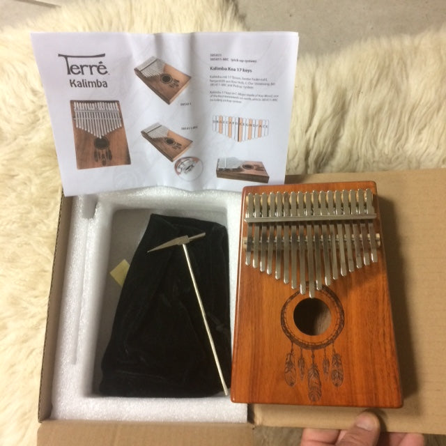 The kalimba or finger piano! 17 notes, made of koa wood (tropical resonance wood) in the key of C major. Decorated with a carved Indian motif and comes with a cloth bag and a tuning hammer! 23x19x7.5 cm!