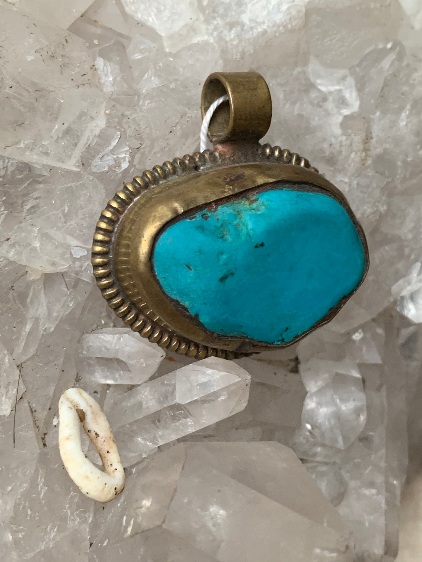 Pendentif artisanal du Népal avec pierres de turquoise sertis sur métal avec de jolies gravures sur la face arrière ! De 38 millimètres de hauteur x 37 mm de largeur x 14 d'épaisseur. Vendu avec cordon noir réglable offert, parfait !
