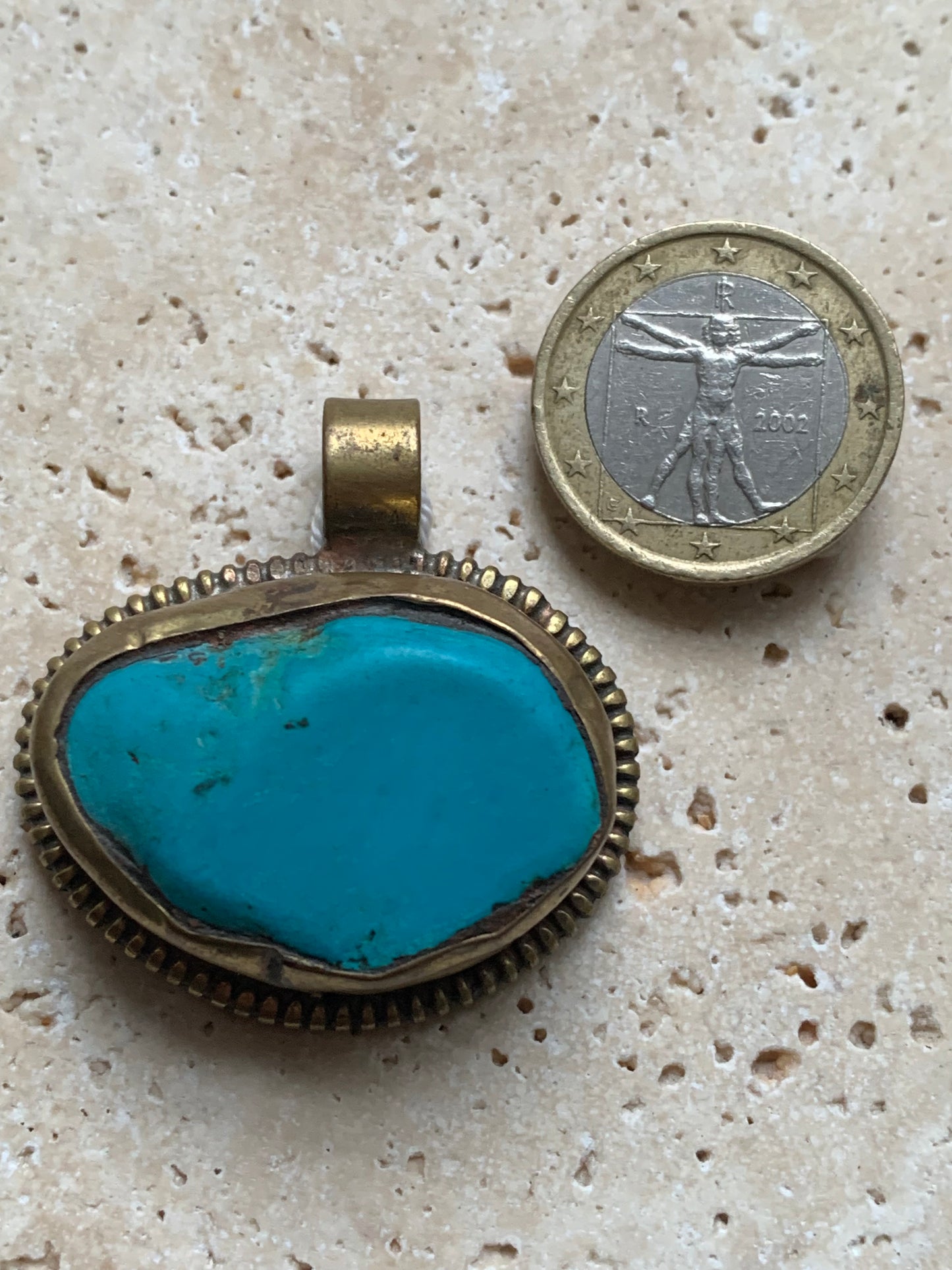 Pendentif artisanal du Népal avec pierres de turquoise sertis sur métal avec de jolies gravures sur la face arrière ! De 38 millimètres de hauteur x 37 mm de largeur x 14 d'épaisseur. Vendu avec cordon noir réglable offert, parfait !