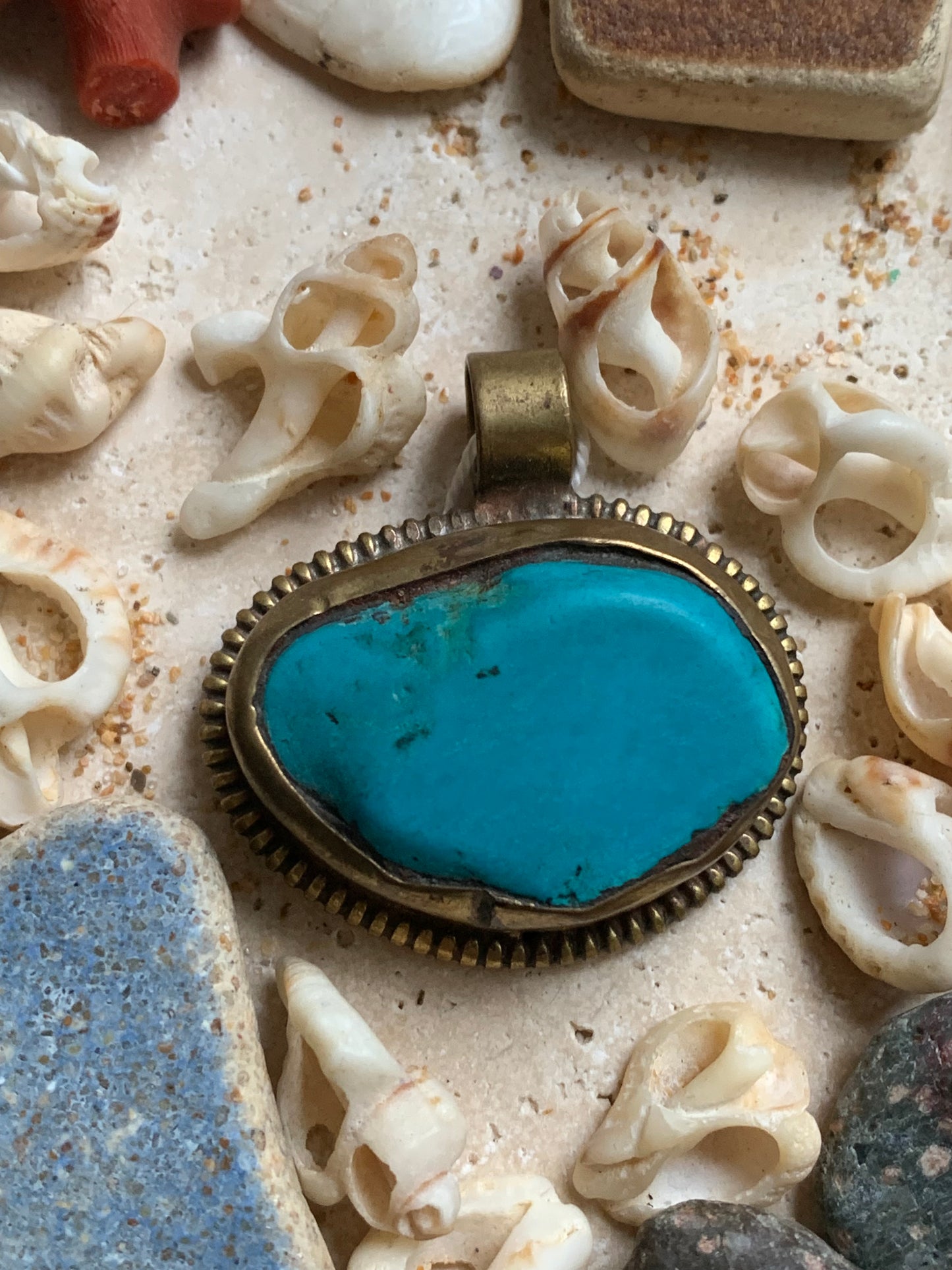 Pendentif artisanal du Népal avec pierres de turquoise sertis sur métal avec de jolies gravures sur la face arrière ! De 38 millimètres de hauteur x 37 mm de largeur x 14 d'épaisseur. Vendu avec cordon noir réglable offert, parfait !