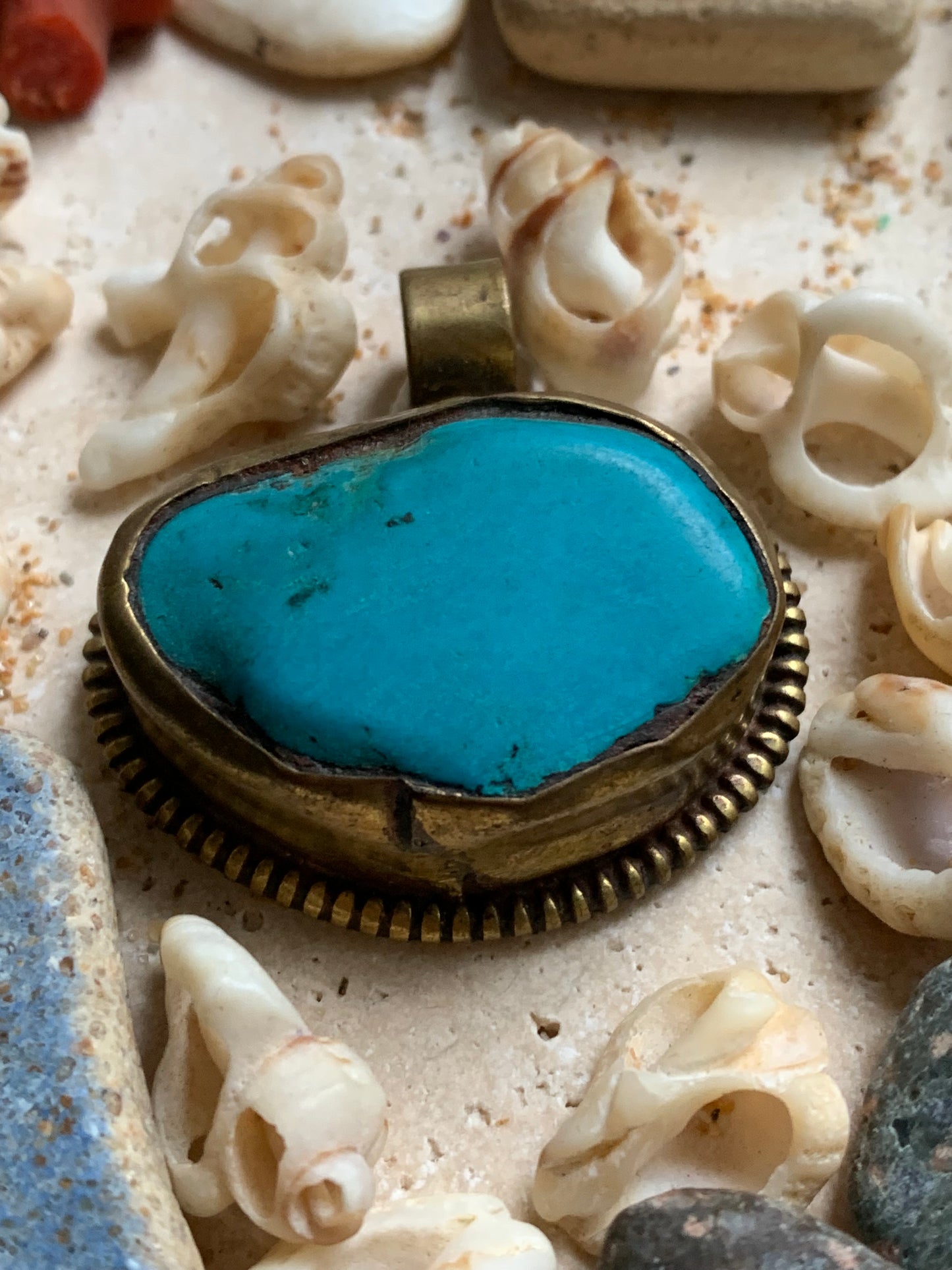 Pendentif artisanal du Népal avec pierres de turquoise sertis sur métal avec de jolies gravures sur la face arrière ! De 38 millimètres de hauteur x 37 mm de largeur x 14 d'épaisseur. Vendu avec cordon noir réglable offert, parfait !
