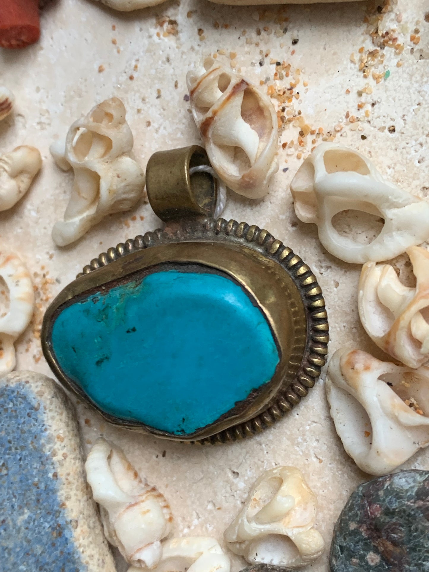 Pendentif artisanal du Népal avec pierres de turquoise sertis sur métal avec de jolies gravures sur la face arrière ! De 38 millimètres de hauteur x 37 mm de largeur x 14 d'épaisseur. Vendu avec cordon noir réglable offert, parfait !