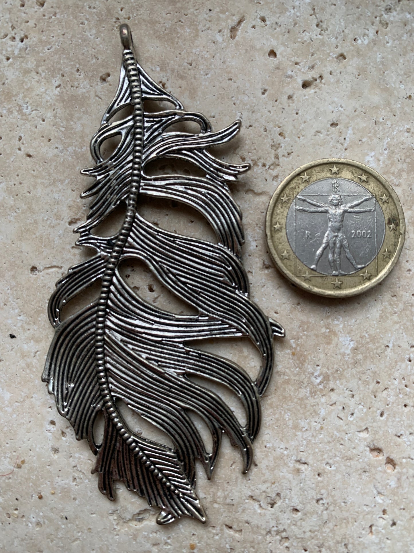 Pendentif en métal argenté en forme de plume. De 85 x 40 x 5 millimètres. Vendu avec cordon noir réglable offert, parfait !