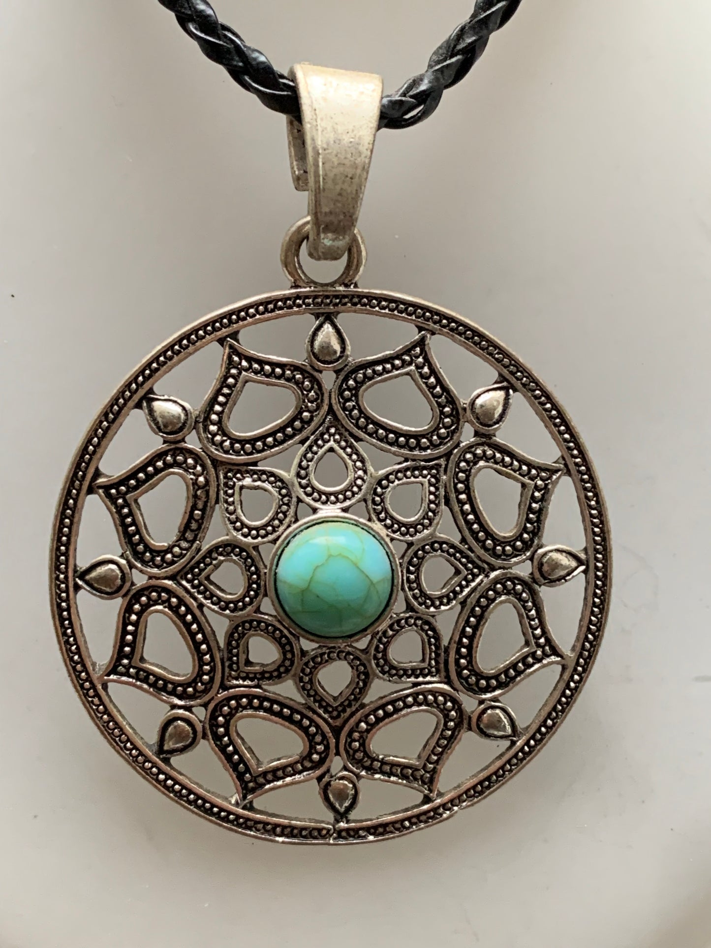 Pendentif en métal argenté en forme de Mandala avec cabochon d'howlite bleue au centre. De 48 x 12 millimètres. Vendu avec cordon noir réglable offert, parfait !