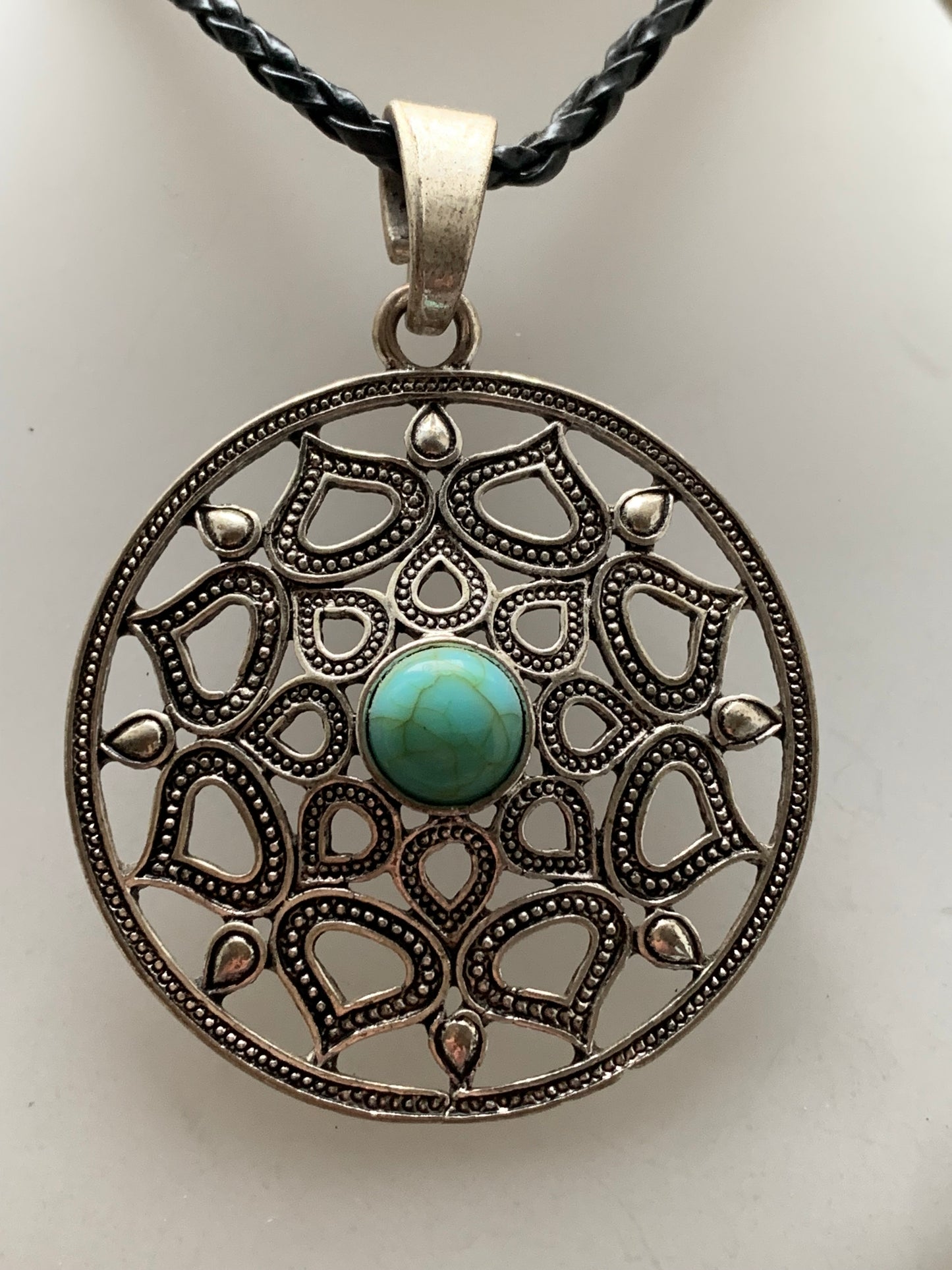 Pendentif en métal argenté en forme de Mandala avec cabochon d'howlite bleue au centre. De 48 x 12 millimètres. Vendu avec cordon noir réglable offert, parfait !