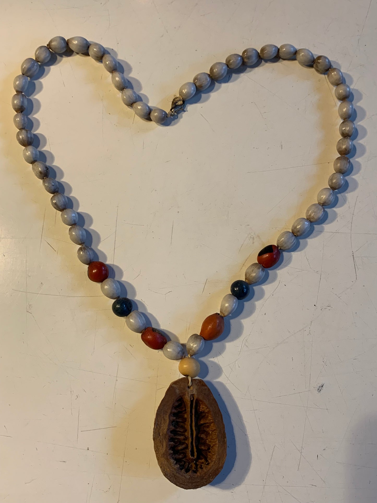 Collier du Pérou en graines naturelles, perles de ± 8 à 10 millimètres. Taille de 55 centimètres de longueur environ + pendentif (coque). Superbe pièce !