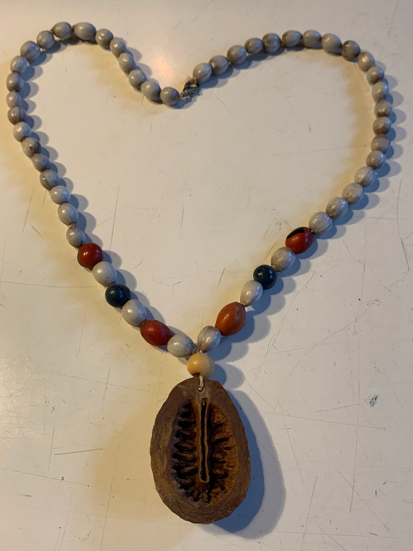 Collier du Pérou en graines naturelles, perles de ± 8 à 10 millimètres. Taille de 55 centimètres de longueur environ + pendentif (coque). Superbe pièce !