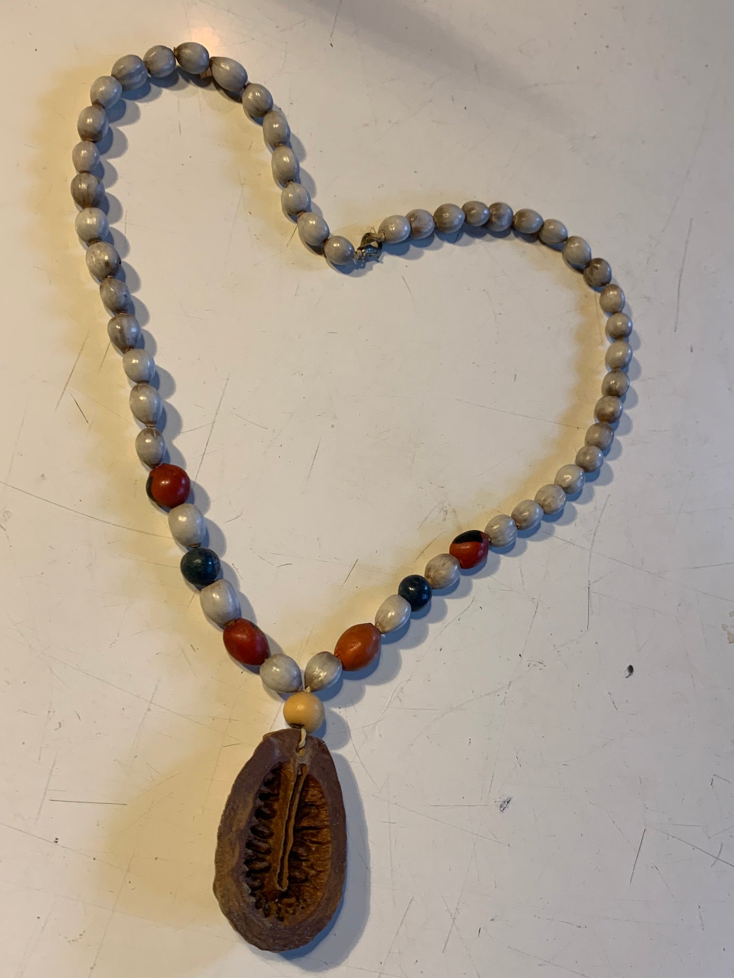 Collier du Pérou en graines naturelles, perles de ± 8 à 10 millimètres. Taille de 55 centimètres de longueur environ + pendentif (coque). Superbe pièce !