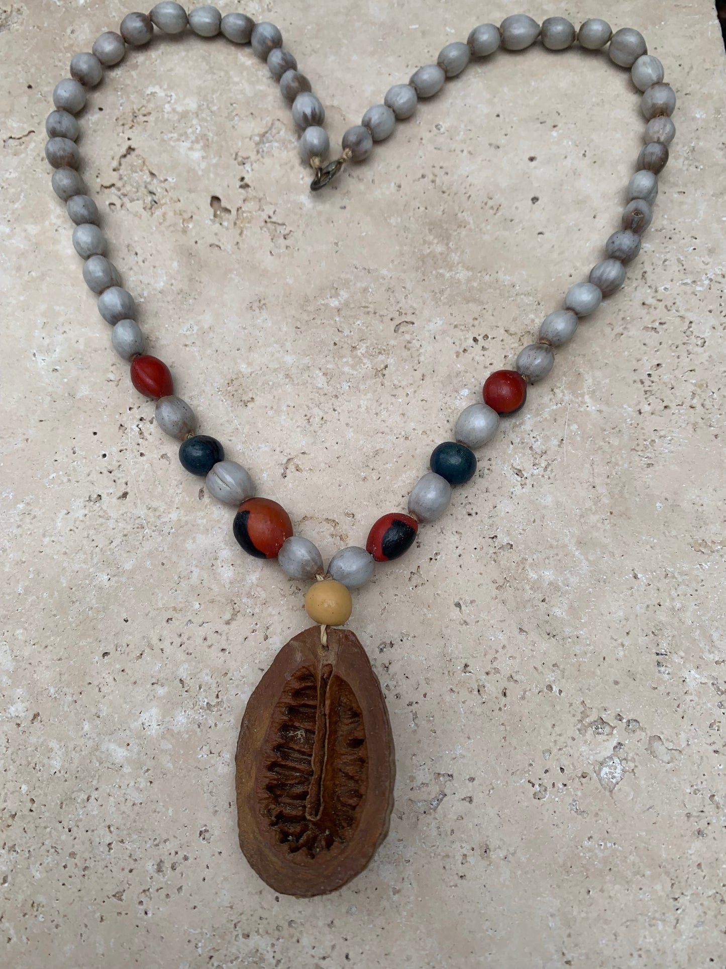 Collier du Pérou en graines naturelles, perles de ± 8 à 10 millimètres. Taille de 55 centimètres de longueur environ + pendentif (coque). Superbe pièce !