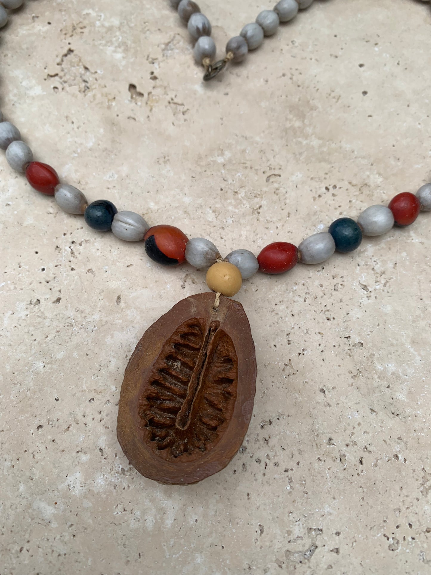 Collier du Pérou en graines naturelles, perles de ± 8 à 10 millimètres. Taille de 55 centimètres de longueur environ + pendentif (coque). Superbe pièce !