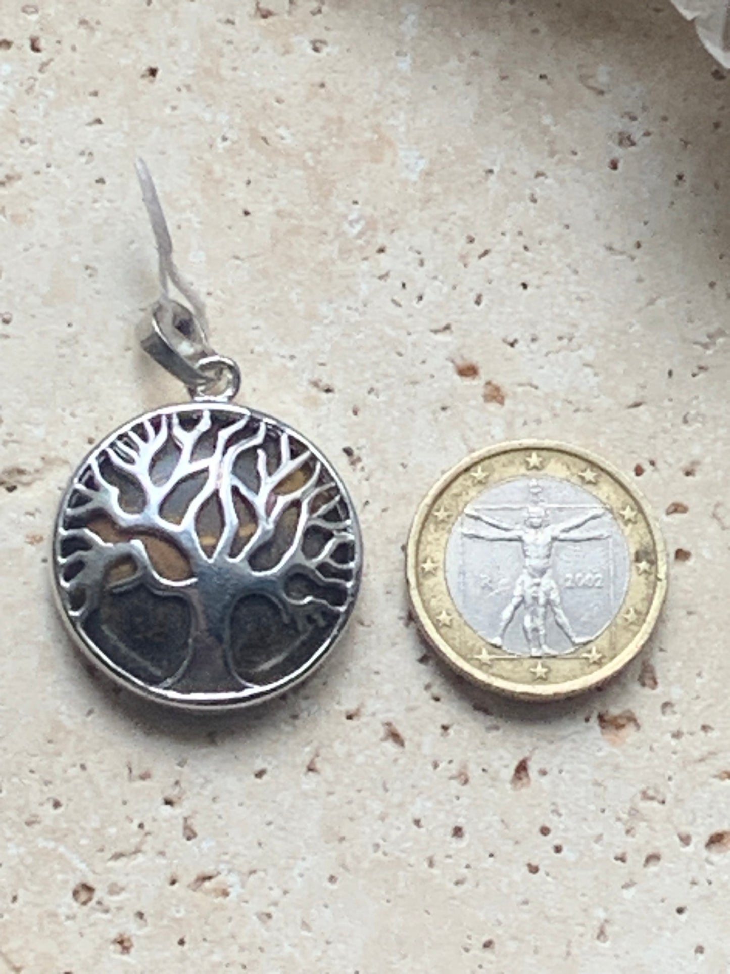 Pendentif en métal argenté 'Arbre de vie' avec un oeil de tigre en fond, de 27 mm de diamètre. Vendu avec cordon noir réglable, parfait !