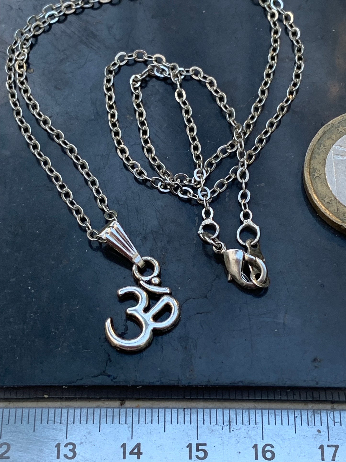 Om, pendentif en laiton argenté, de 23x12x2 millimètres -1,3 gr. Vendu avec cordon noir réglable offert, parfait !