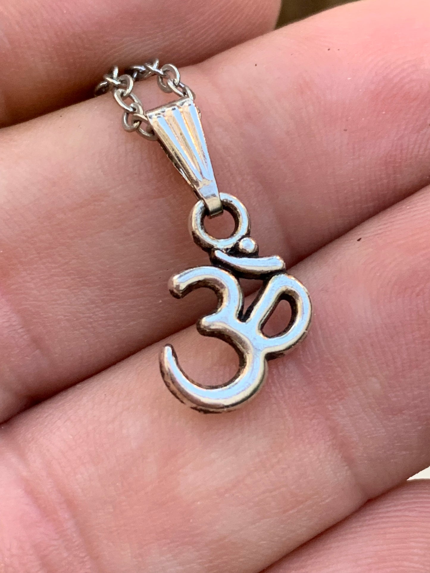 Om, pendentif en laiton argenté, de 23x12x2 millimètres -1,3 gr. Vendu avec cordon noir réglable offert, parfait !