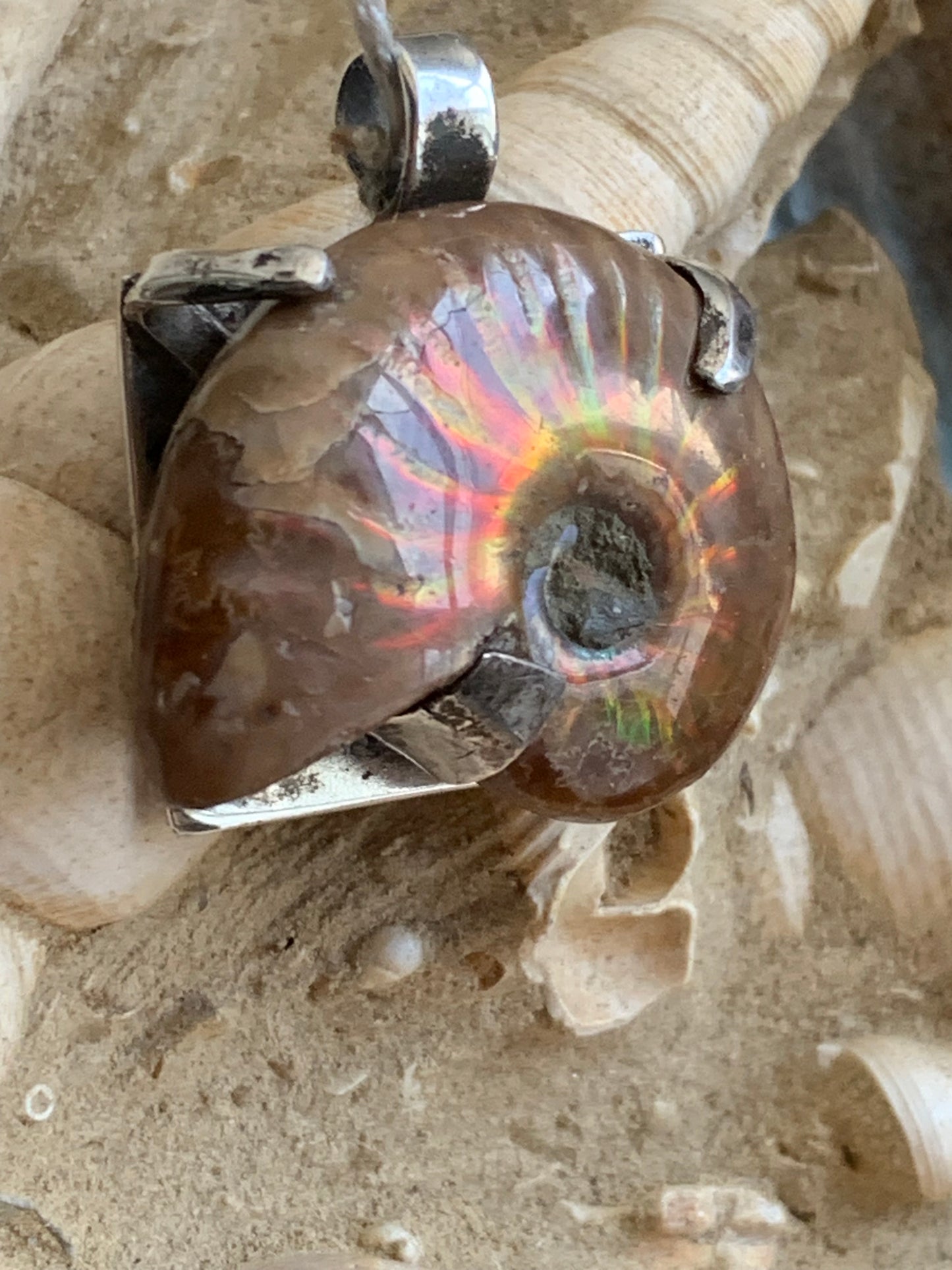 Ammonite nacré, joli pendentif avec structure en Argent 025 rhodié. Taille de 31 millimètres x 30 x 12. Vendu avec ou sans cordon noir et réglable de 60 cm !