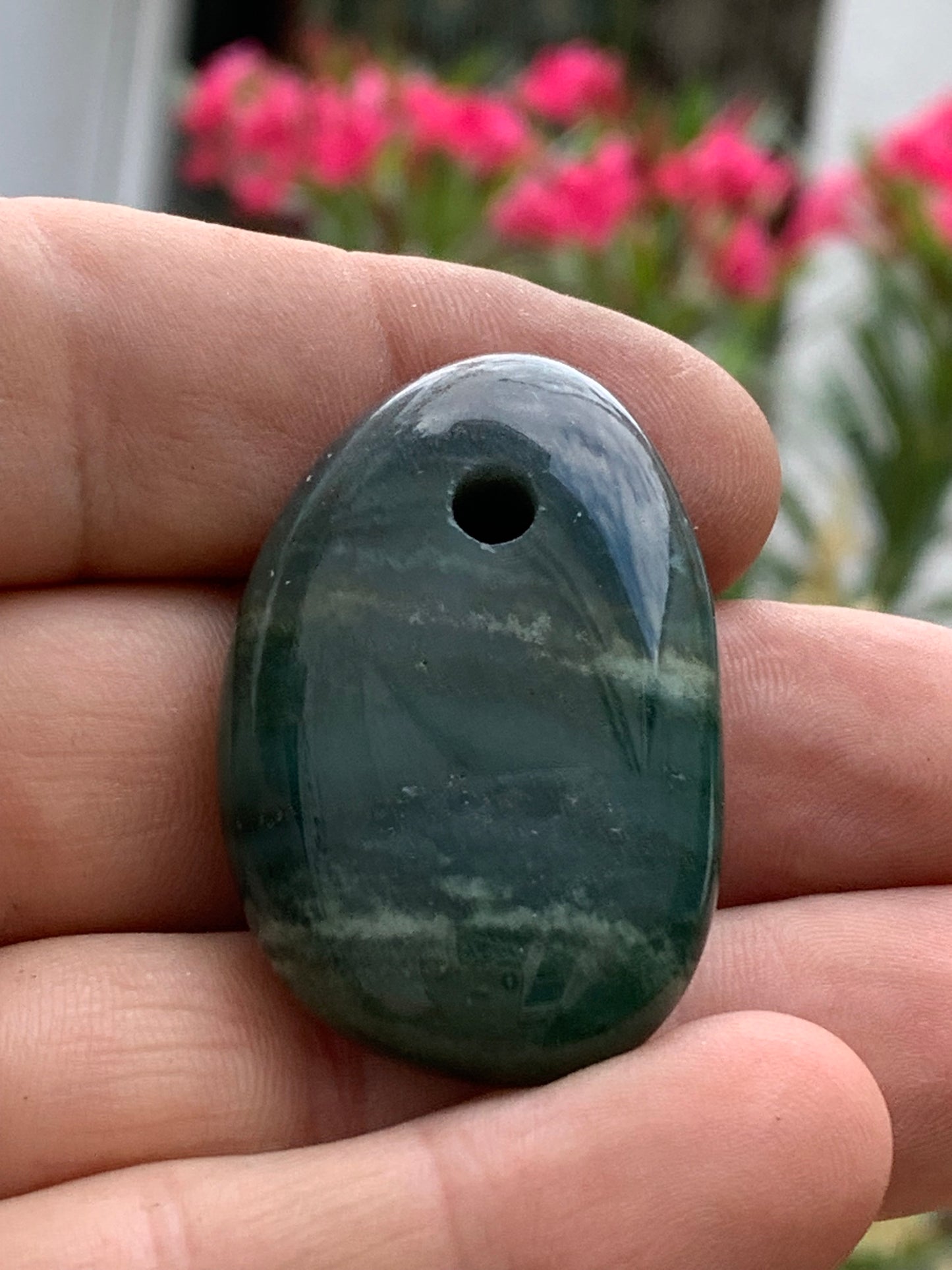 Jade, galet percé 43 mm de hauteur x 30 de largeur x 12 d'épaisseur. Vendu avec cordon réglable de couleur noire.