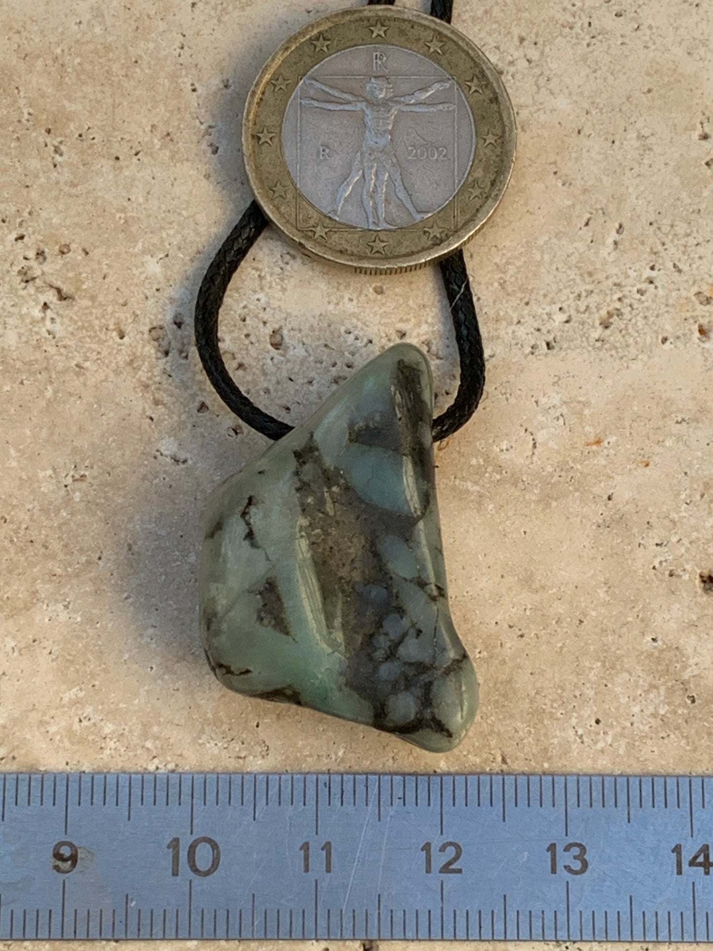 Émeraude, pierre brute percée de 33mm x21 x12 - 12,4 grammes. Vendu avec cordon noir réglable !