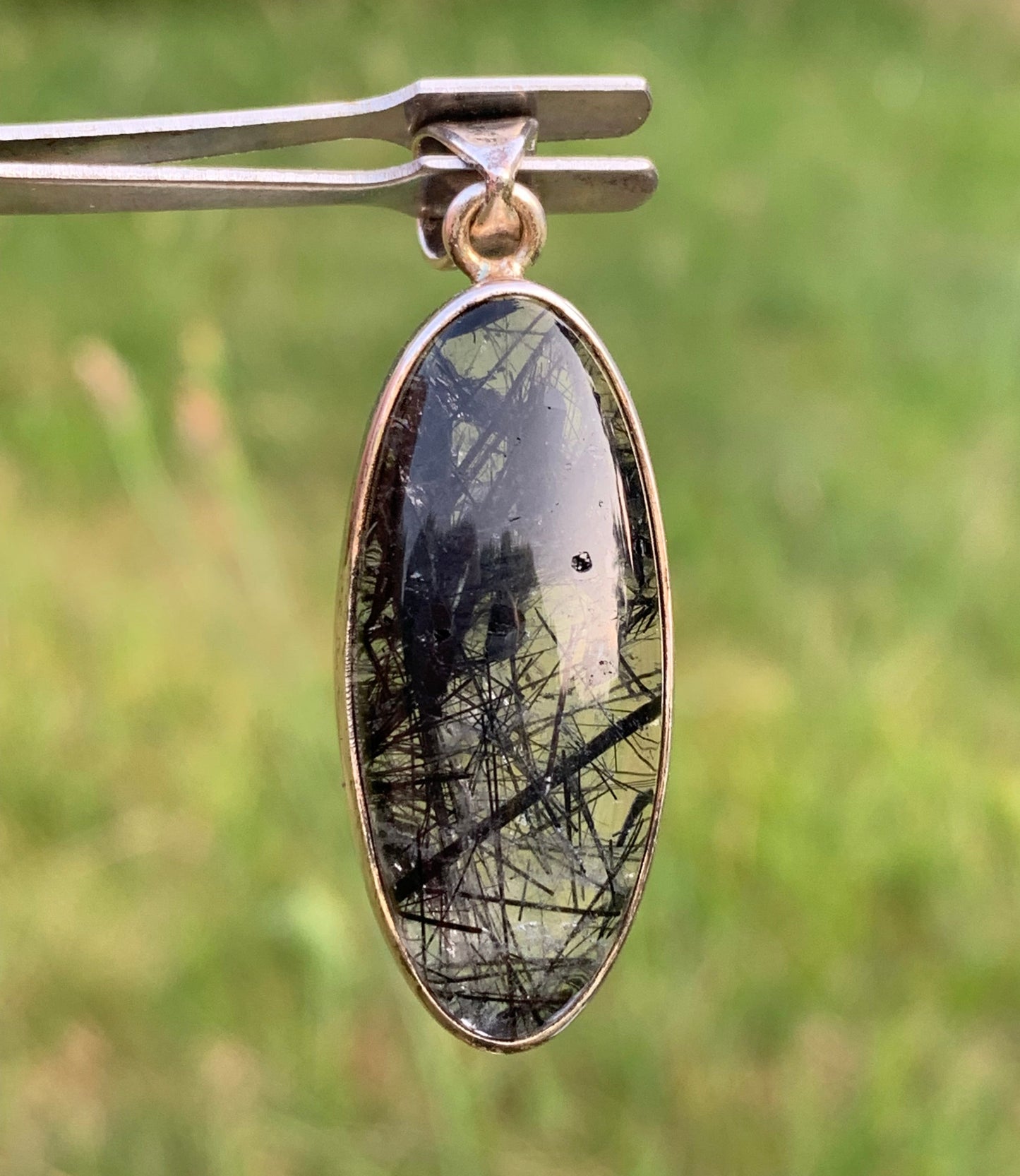 Rock crystal/quartz with black tourmaline inclusions! Silver pendant, 45mm high x15 x8. Sold with adjustable black cord!