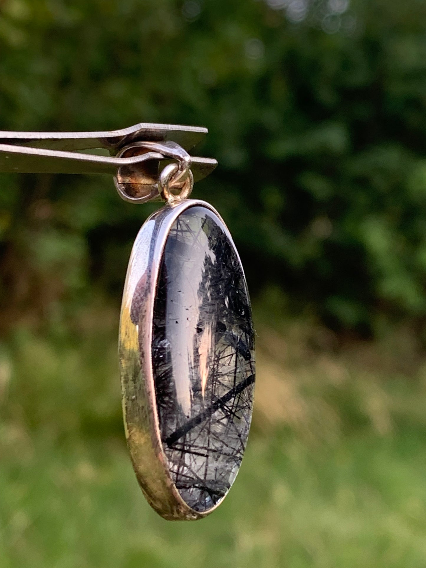 Rock crystal/quartz with black tourmaline inclusions! Silver pendant, 45mm high x15 x8. Sold with adjustable black cord!
