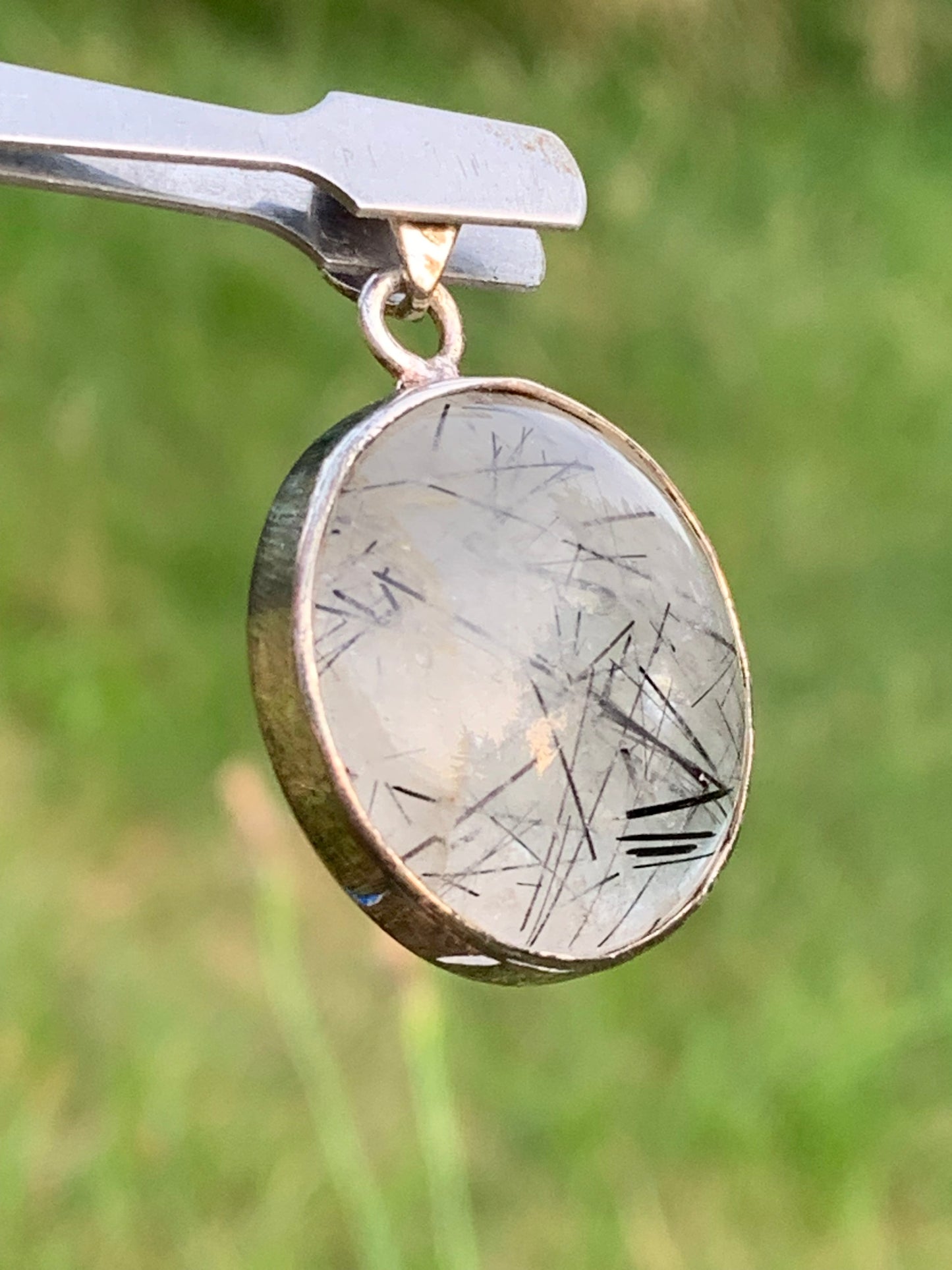 Rock crystal/quartz with black tourmaline inclusions! Silver pendant, 35mm high x26 x8. Sold with an adjustable black cord!