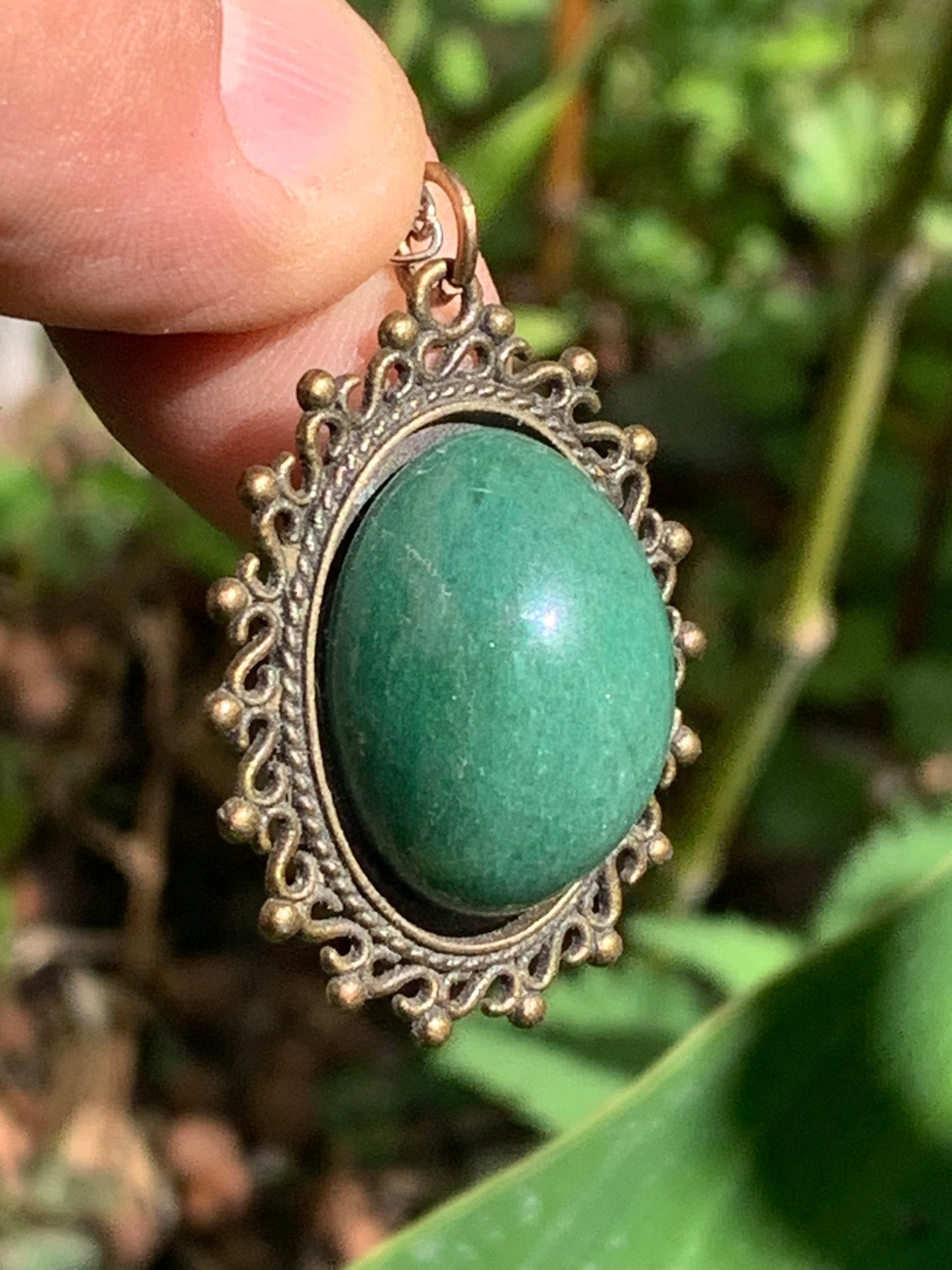 Bronze-colored medallion with Aventurine/green quartz, 36 mm high x 30 x 3. Sold with an adjustable black cord!