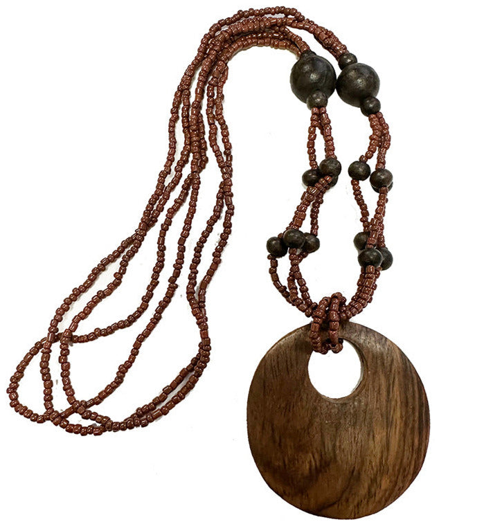 Collier/ sautoir de perles et pendentif en bois. Longueur : environ 62 centimètres. Dimension pendentif : environ 6 centimètres !