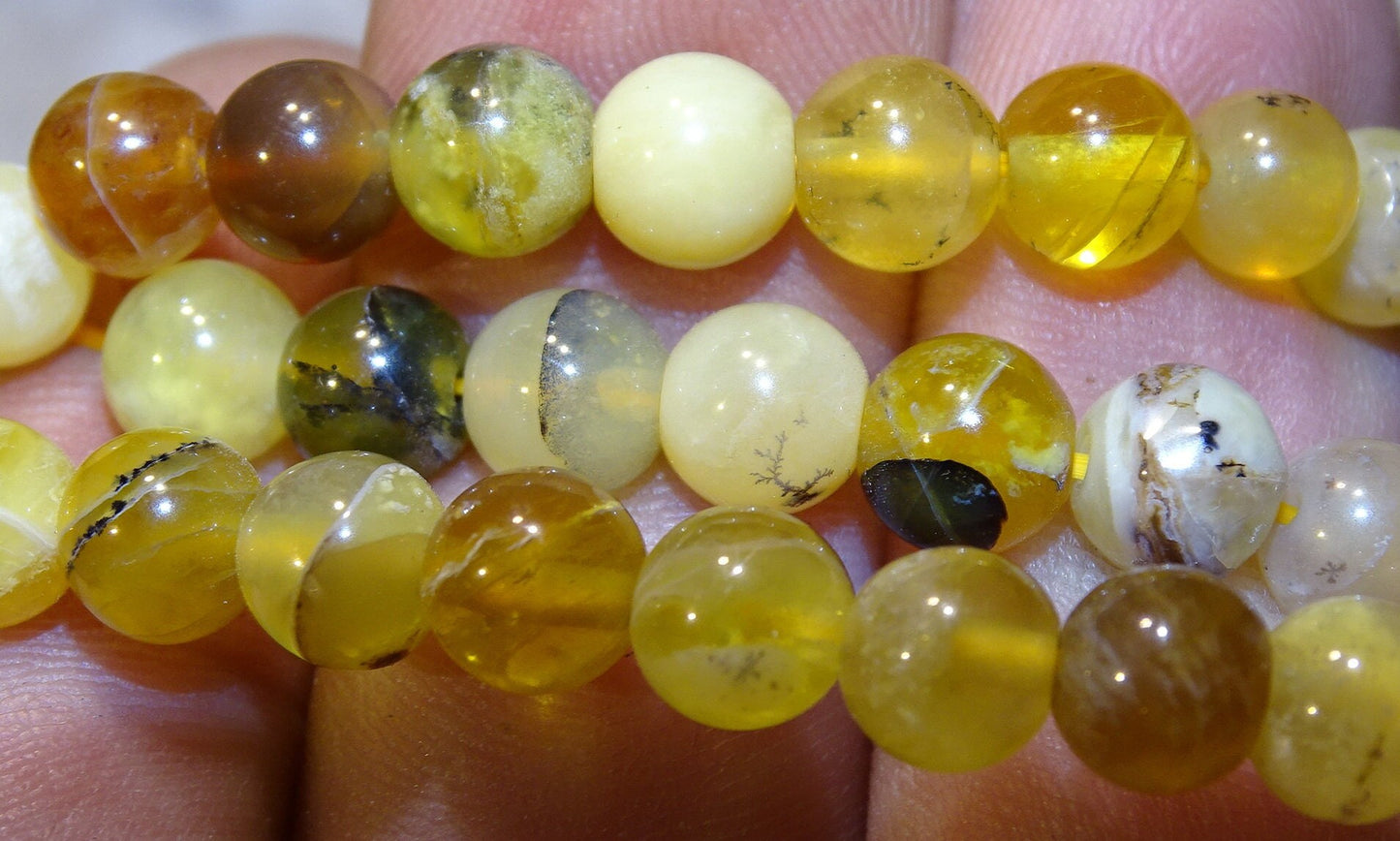 Australian yellow opal, round beads of 4, 6 or 8 mm. Sold in 38/39 cm bead strand, in 17 to 21 cm bracelets, in 45 cm necklaces or 60 cm sautoirs. AA to AAA quality, superb beads with dentric reflections!
