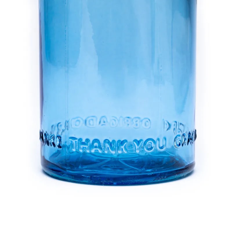 Bouteille de 0,5 litres de chez 'Om Water' modèle 'Gratitude', fabriquer suivant le nombre d'Or. En verre 100% recyclé, 0% métaux lourds, vendu dans un sac en coton naturel.