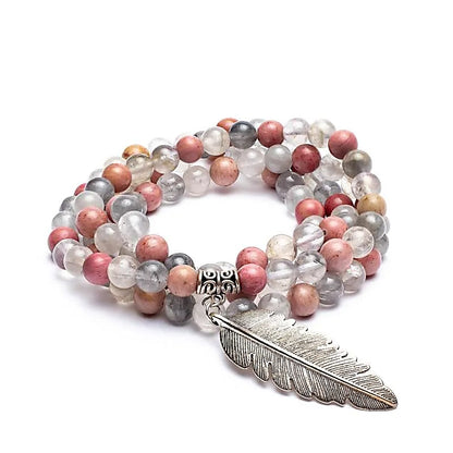 Mala en Rhodonite/ Quartz fumé avec en finition une superbe plume, de 108 perles de ± 8 millimètres. Taille de 85 centimètres de longueur environ. Qualité AA à AAA, superbe pièce avec pochette de rangement offerte. Fait en Inde !