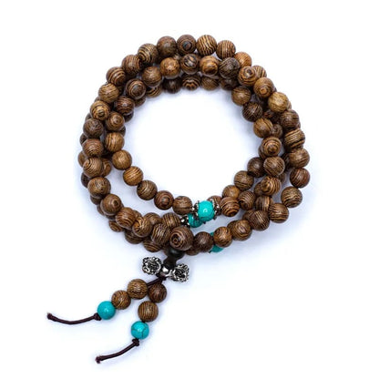 Mala de bois avec perles ornementales et finition avec 'Dorje', de 108 perles de ± 6 millimètres. Taille de 60 centimètres de longueur environ. Superbe pièce avec pochette de rangement offerte. Fait en Inde !